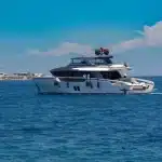 Due persone sorridenti su uno yacht di lusso nel Mediterraneo al tramonto