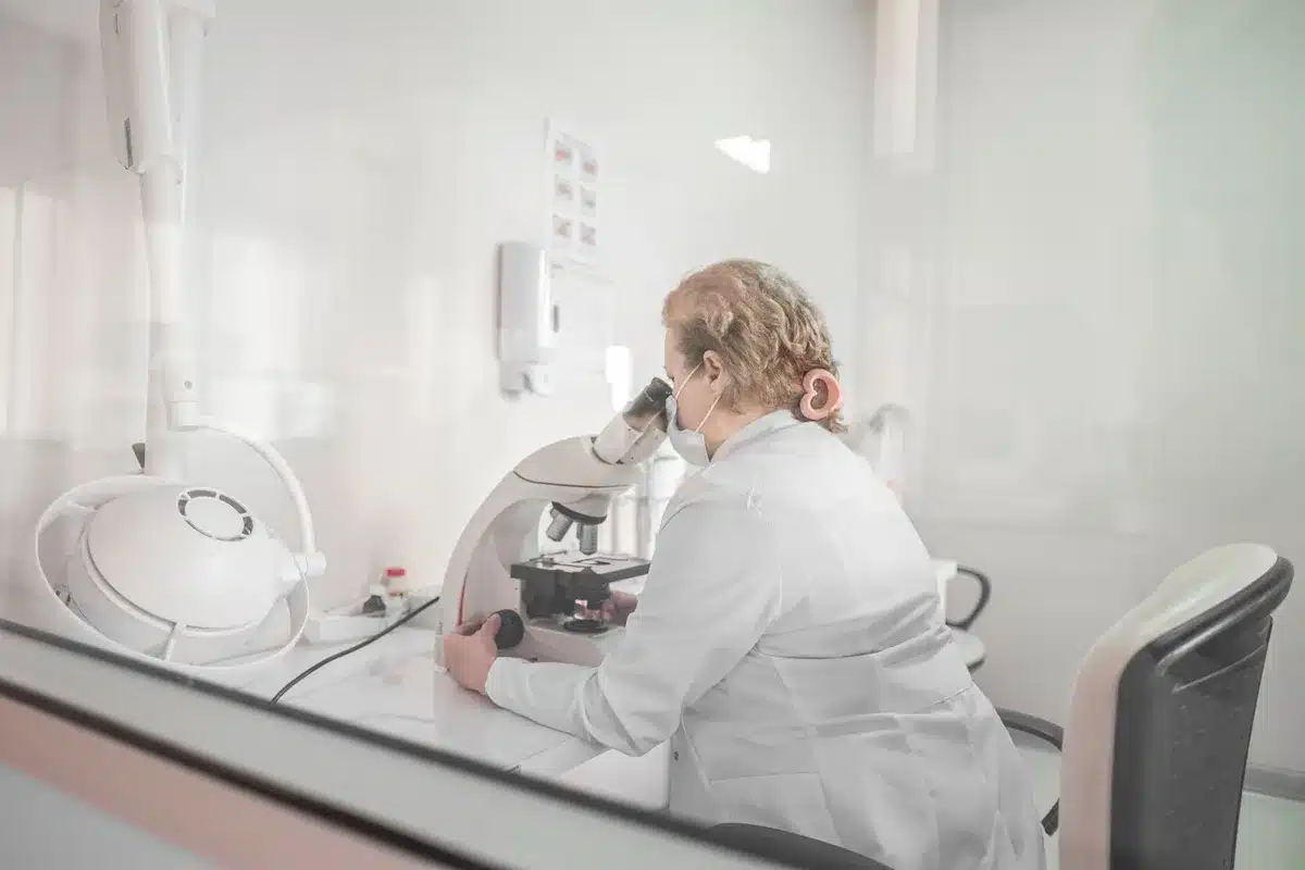 Una ricercatrice in laboratorio esamina campioni di pelle sotto il microscopio
