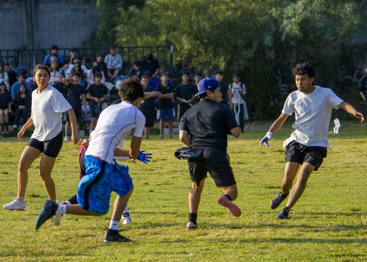 Atleti universitari da diverse nazioni riuniti in una piazza storica con bandiere internazionali