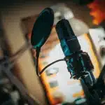 Artista che canta in uno studio di registrazione con microfono e luci professionali