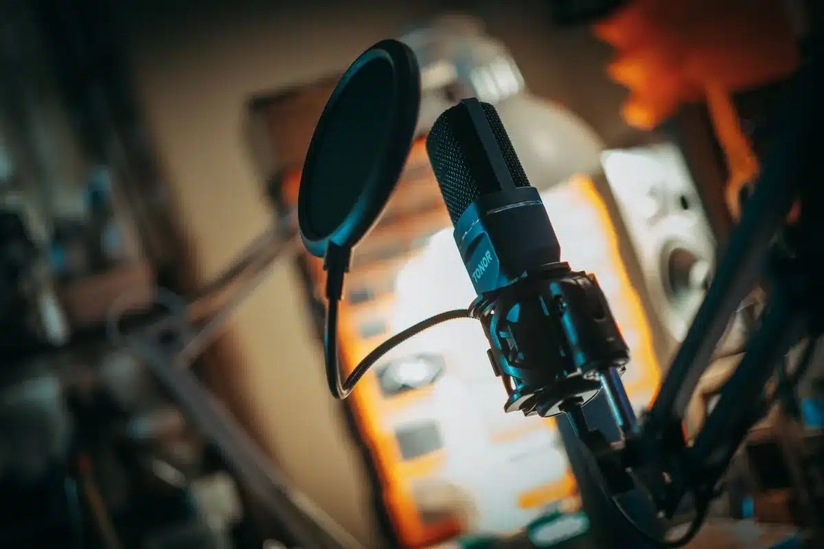 Artista che canta in uno studio di registrazione con microfono e luci professionali