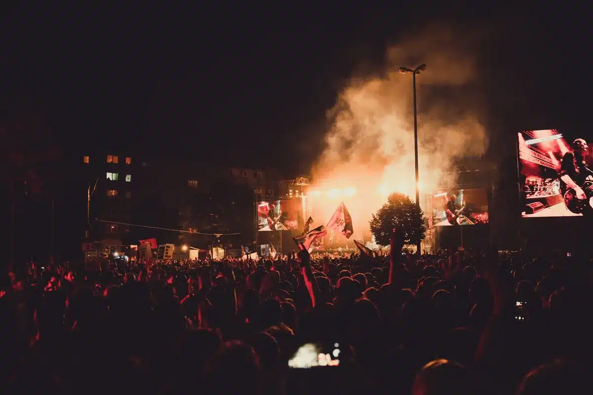 Spettacolo dal vivo su palco con pubblico e illuminazione scenica in location costiera