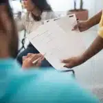 Documenti fiscali e armband da volontario su una scrivania con calendario annuale