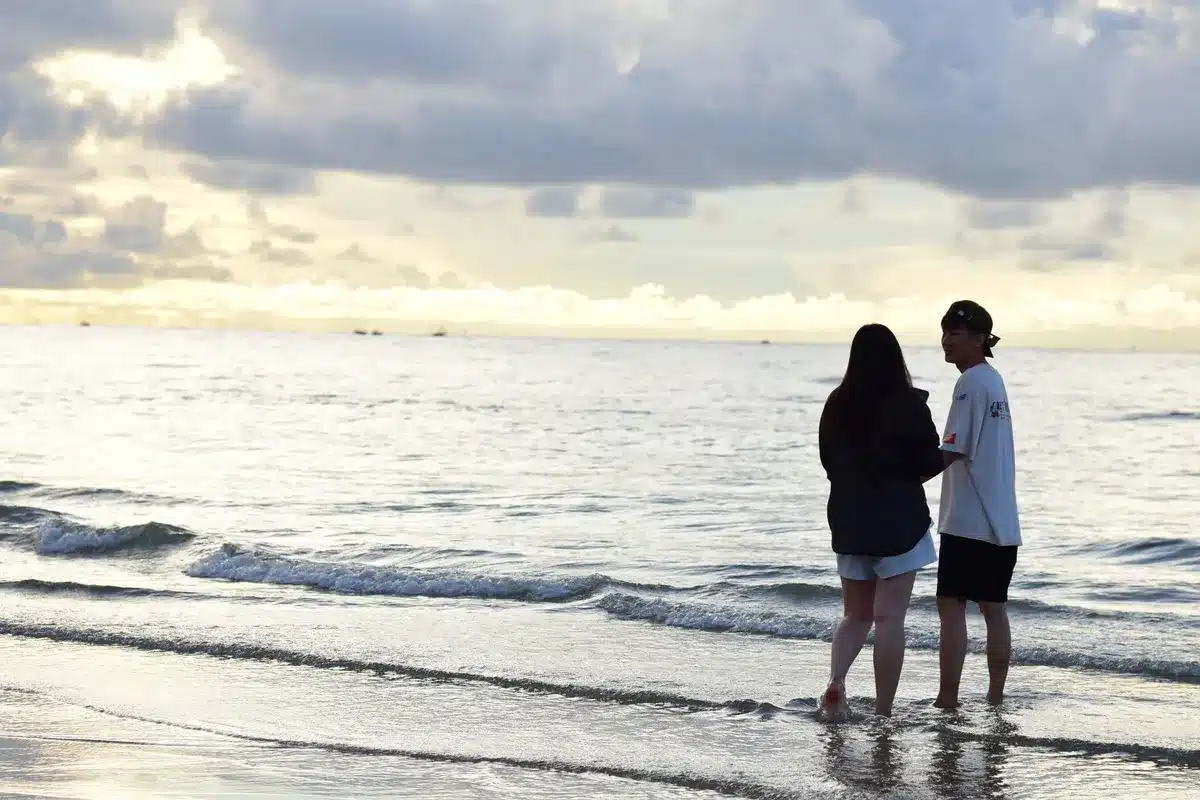 Una coppia si rilassa in spiaggia al tramonto in un'atmosfera romantica.