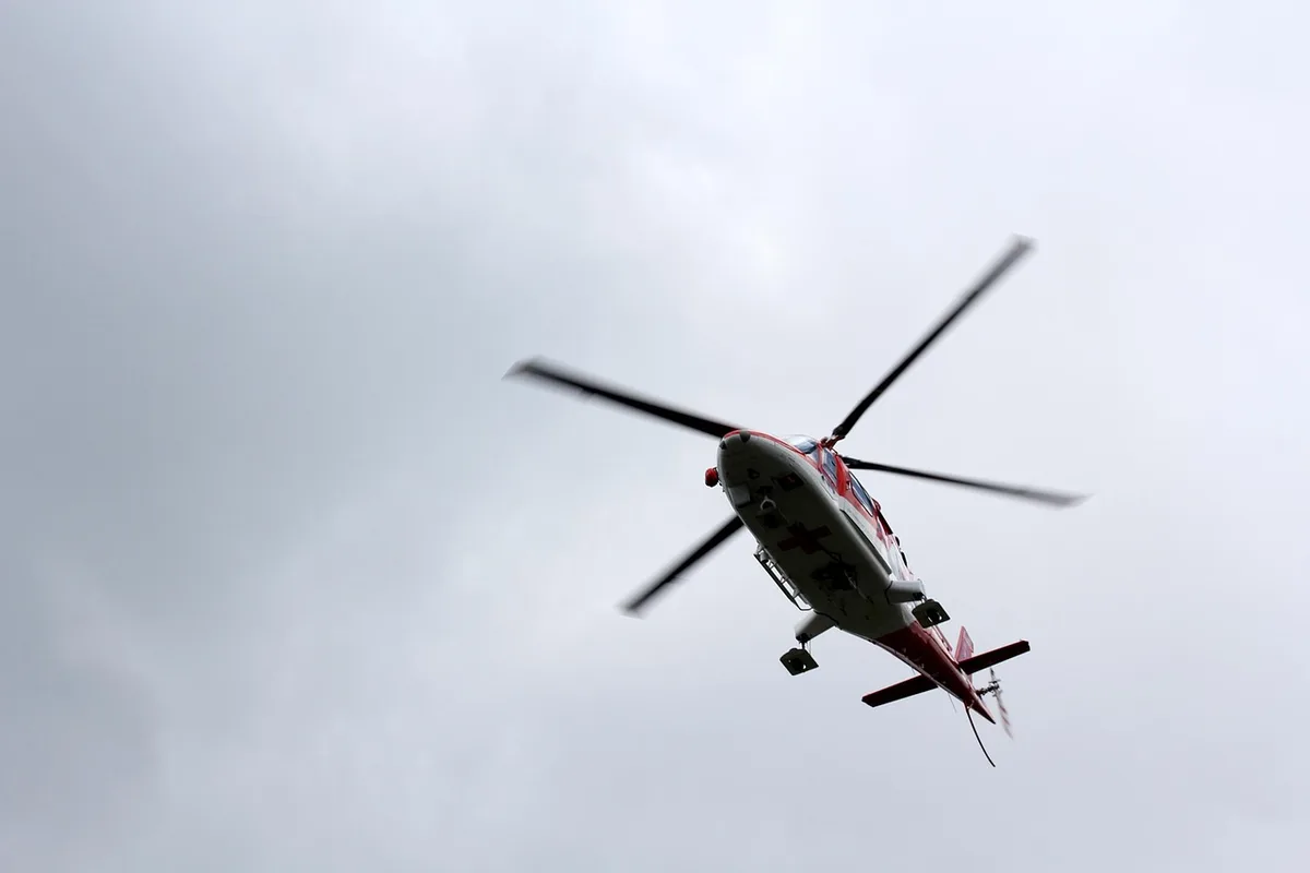 Operazioni di soccorso in zona montuosa allagata con acqua in piena e macerie sparse