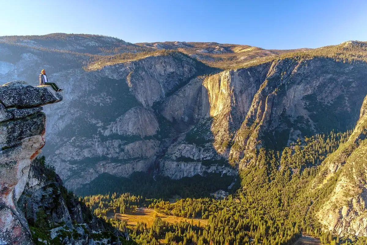 Enorme frammento di ghiacciaio che precipita da una montagna causando valanga e distruzione nella valle sottostante