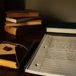 Mani che tengono un certificato medico accanto a un computer portatile con il portale INPS sullo schermo