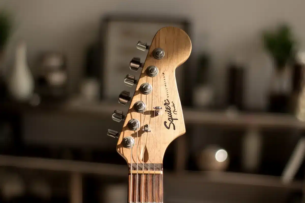 Chitarra elettrica e microfono su un piccolo palco in una sala prove, luce calda