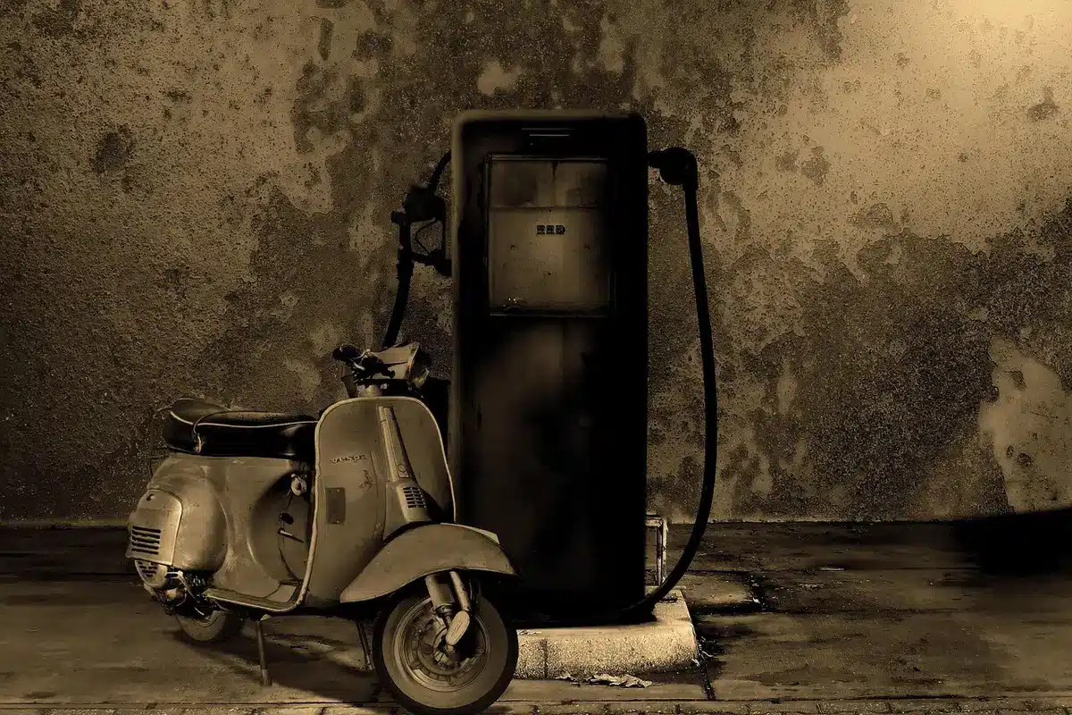 Pannello prezzi carburante e auto in coda alla pompa
