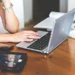 Mani anonime su documenti e smartphone su una scrivania d'ufficio