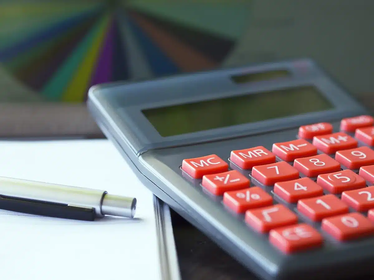 Persona che calcola una pensione con moduli e calcolatrice