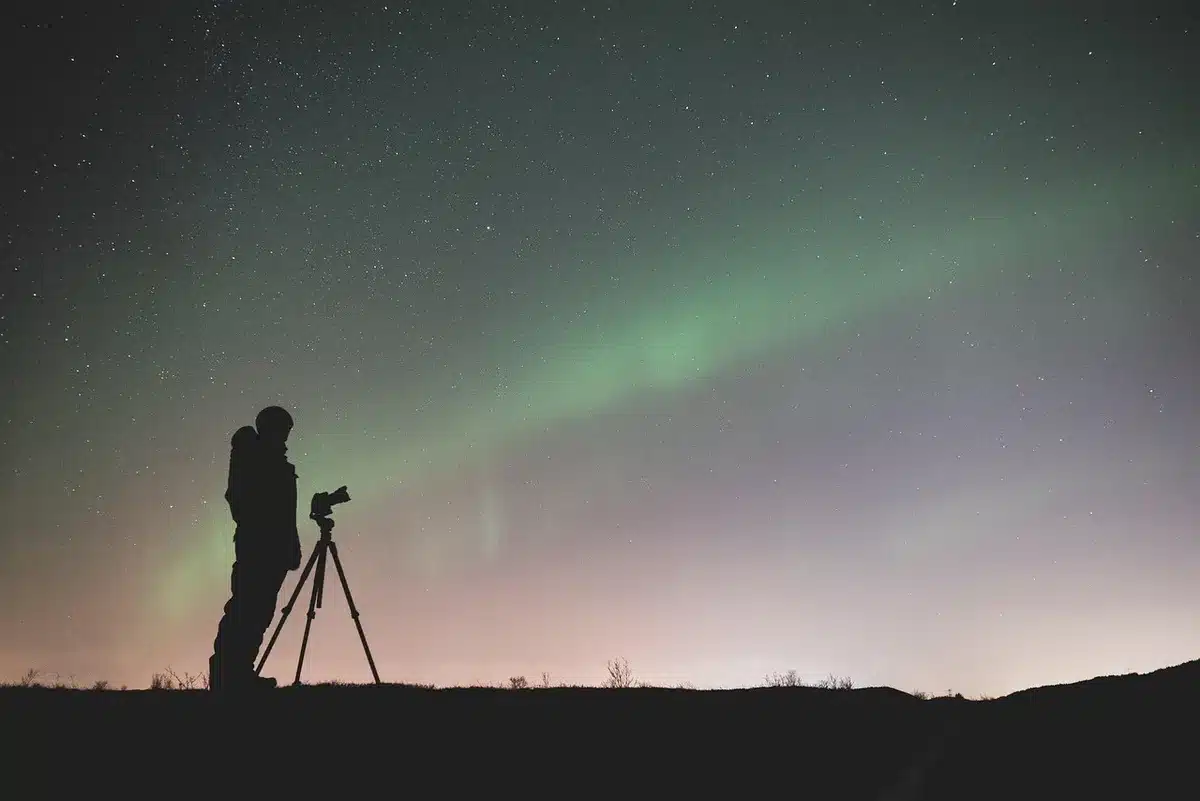 Silhouette di due giornalisti che ripongono una telecamera e un microfono in una strada stretta