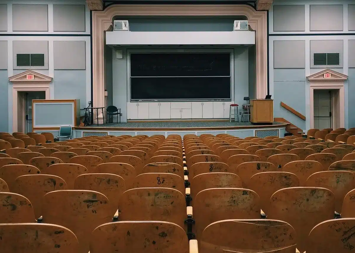 Mani che tengono un vinile e un diploma, ambiente accademico sfocato